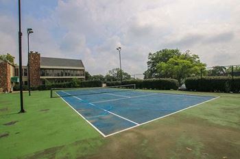a tennis court with a building in the background